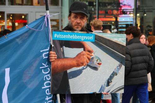 Activist met een protestbord ''#vissenhebbengevoel''
